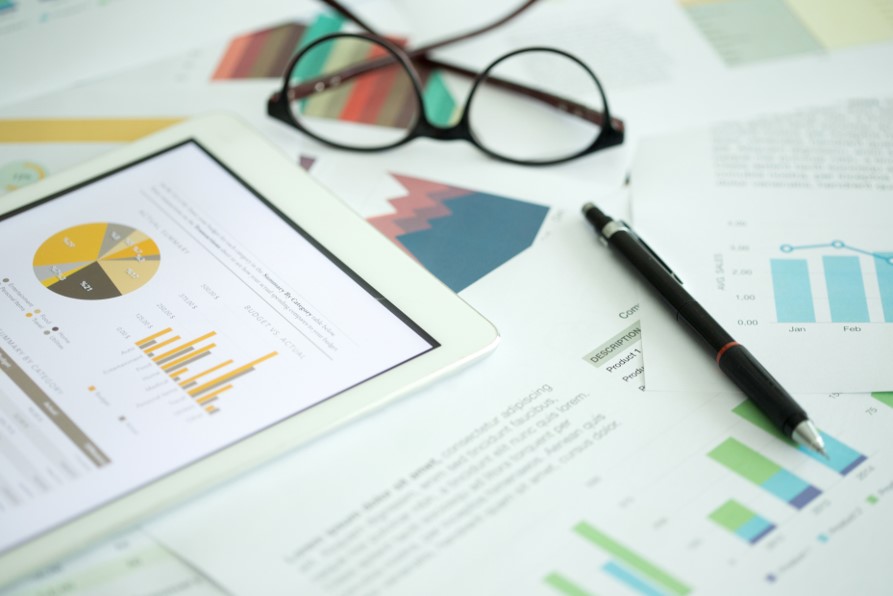 Paper financial reports by eye glasses and pen Paper financial reports by eye glasses and pen